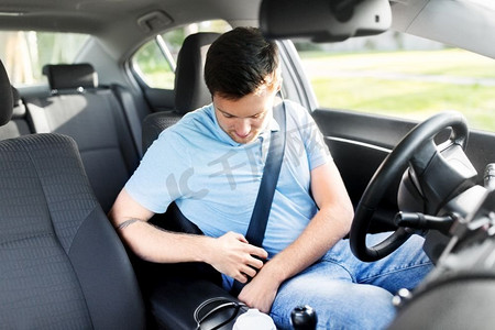 交通、车辆及安全驾驶概念——夏季男女司机系好安全带。男子或汽车驾驶员系紧安全带