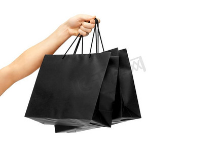 零售和黑色星期五促销概念-女性手持白色背景的黑色购物袋。女性手持黑色购物袋