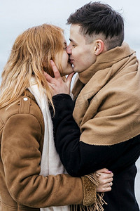 冬天冬季卡通摄影照片_年轻的夫妇亲吻冬天