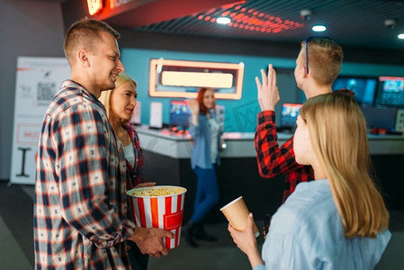 一群朋友在电影院售票处买票。男女青年在电影院等待，娱乐生活方式