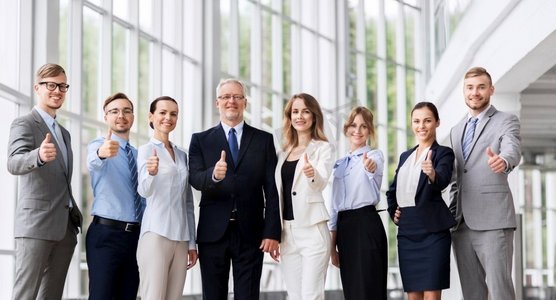 理念商务摄影照片_人，工作和企业理念—快乐的业务团队在办公室竖起大拇指。商务人士在办公室竖起大拇指