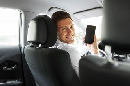 交通、驾驶和科技概念--男人或汽车司机展示智能手机。展示智能手机的男人或汽车司机
