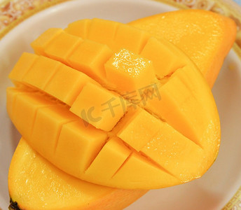 芒果热带水果甜和成熟的芒果切片立方体在板关闭