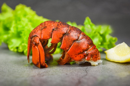 背景板红色背景摄影照片_龙虾尾巴在黑暗板背景/红色龙虾食物在餐桌上