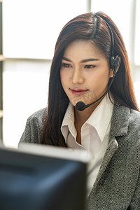 亚洲年轻人友好和自信的呼叫中心的肖像，在呼叫中心使用耳机作为客户服务和技术支持。