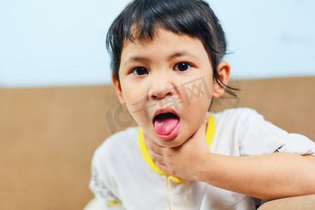 小女孩给猫打伞摄影照片_咳嗽和喉咙疼痛/亚洲小女孩发烧感冒，孩子伸出舌头