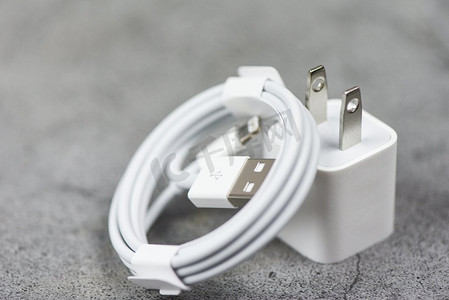 灰色文理摄影照片_电子适配器智能手机USB端口充电器线在灰色背景上/手机充电器适配器