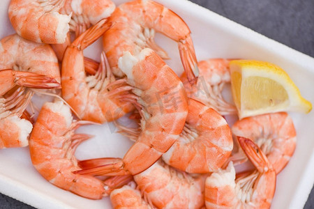 水煮虾虾在海鲜餐厅烹调食物，鲜虾放在盛有柠檬的塑料盘上