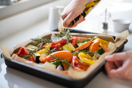 特写调味品托盘的蔬菜烤与橄榄油准备素食餐 