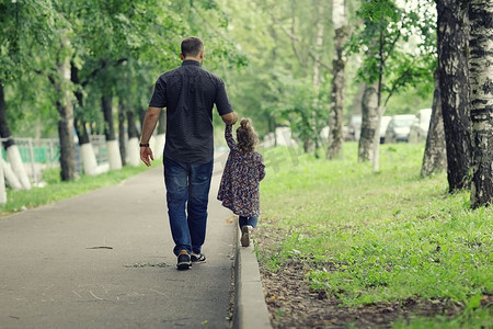 爸爸带着女儿在公园里散步