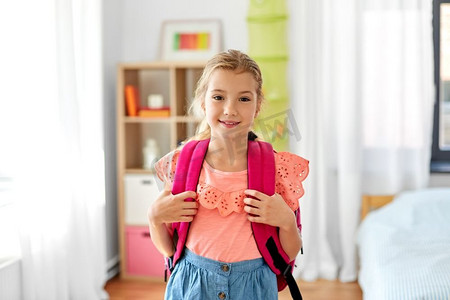 孩子，教育和学习理念--快乐的女学生在家里背着书包。家里背着书包的女学生
