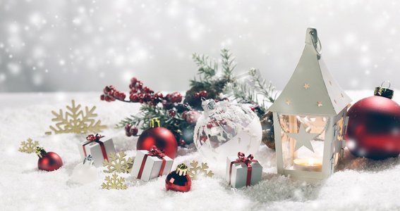 圣诞节假期卡与礼物，球和发光灯笼在雪。圣诞装饰在雪