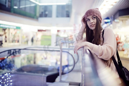 零售摄影照片_一个女孩在一个针织帽子走在商场