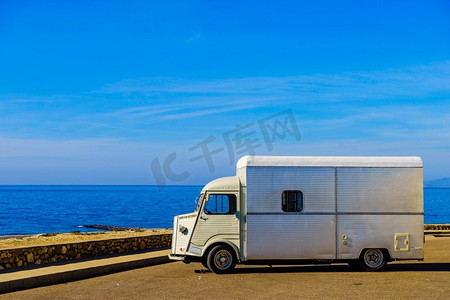 西班牙地中海沿岸的老式大篷车。假期和旅行在汽车之家。复古大篷车露营在海岸