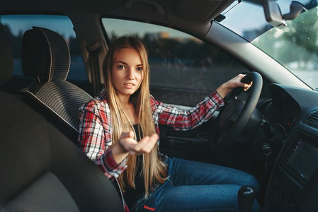 年轻女子初学者提供乘坐汽车。女性在汽车，驾驶汽车概念。年轻女子初学者提供乘坐汽车