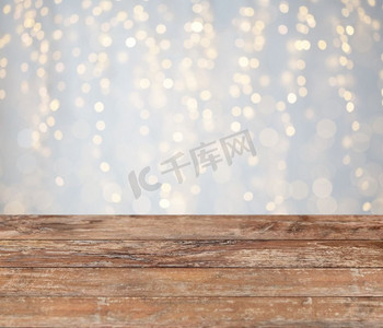 圣诞背景摄影照片_假日概念空的木表面或表与圣诞节金色光背景。空的木桌与圣诞金色的灯光