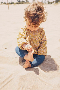玩沙子摄影照片_小女孩在海滩上玩沙子