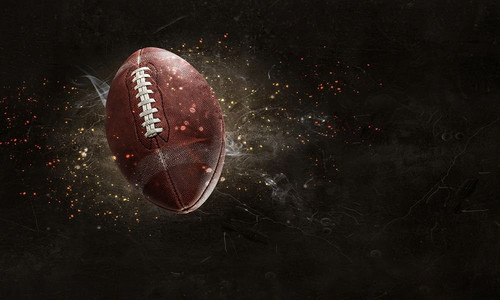 游戏爆炸背景摄影照片_在闪电的橄榄球在黑暗的背景。混合媒体。美式橄榄球比赛