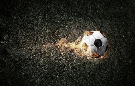 足球比赛的概念与球在火焰。混合媒体。足球着火了
