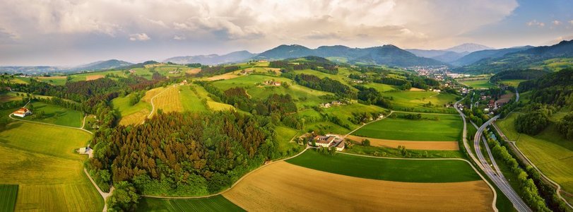 田野路摄影照片_春天在奥地利旅行绿色的田野和草地在阿尔卑斯山。在阿尔卑斯山的乡村的交叉路口。 