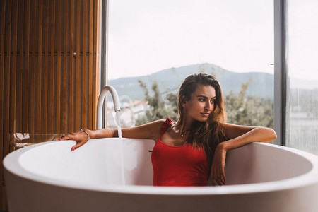 妇女沐浴和放松在现代浴缸