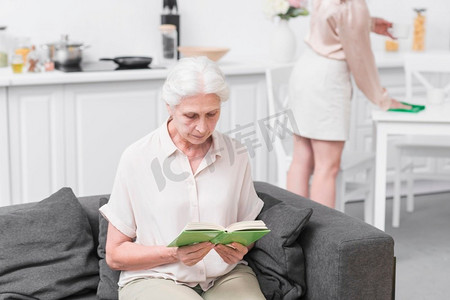 老年妇女坐沙发看书家