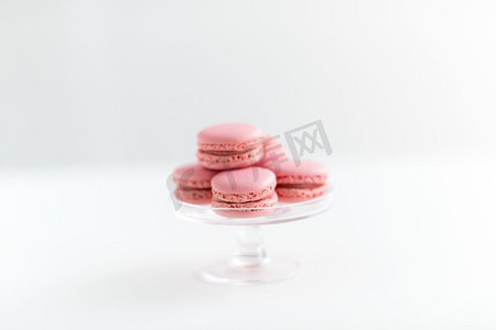 糖果、糕点和食品概念-玻璃糖果上的粉色马卡龙矗立在白色背景上。玻璃糖果摊上的粉色马卡龙