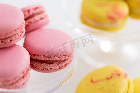 糖果、糕点和食物概念-白色背景上的粉色和黄色马卡龙的特写。粉色和黄色马卡龙的特写