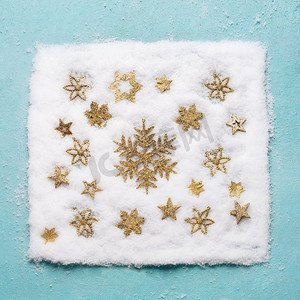 圣诞节金色雪花样式在淡蓝色背景，顶视图的雪。平躺。冬季作文和假期概念