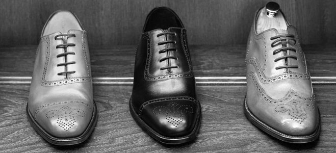 全粒面皮鞋在男鞋精品店的木制陈列中。黑白照片..男士鞋类精品店