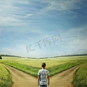 摄影照片_创造性的概念与一个男人在前面的两条道路选择正确的道路