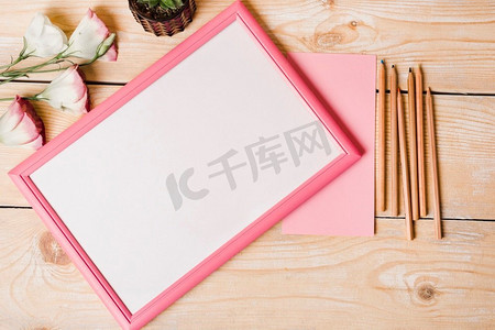 彩色铅笔纸洋桔梗花白色相框与粉红色边框木桌