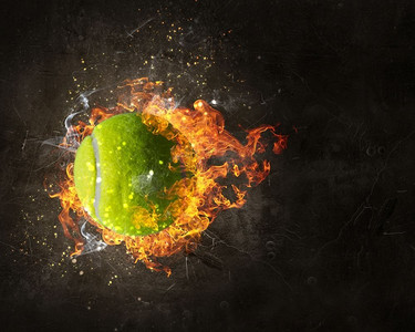 火圈摄影照片_大网球在火火焰在黑暗背景。混合媒体。网球在火