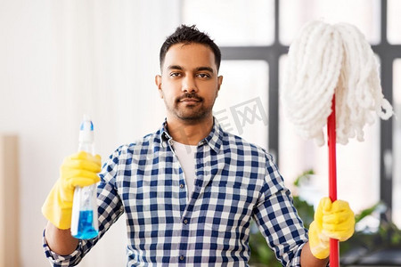 清洁，家务和家政概念—印度男子与拖把和清洁剂在家里。印度男子与拖把和清洁剂清洁在家里