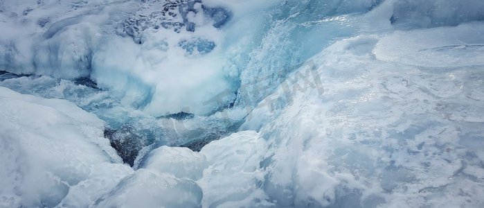 冷淡摄影照片_抽象冻结的河背景，非常寒冷的冬天，作为蓝色的水流动通过雪的冰。