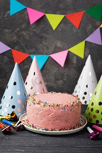 卡通蜡烛蛋糕摄影照片_粉红色蛋糕派对帽装饰
