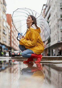 撑着伞的女人站在雨边看