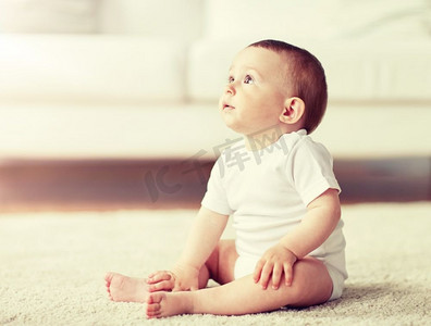 童年，婴儿和人的概念—快乐的小男孩或女孩坐在地板上在家里。快乐的男孩或女孩坐在地板上在家里