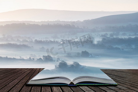 美丽乡村风景摄影照片_美丽的有雾的英国乡村风景在日出在冬天与层滚动通过领域出来的页在神奇的故事书