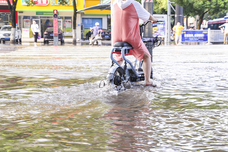 洪涝洪水下的城市骑摩托车的人