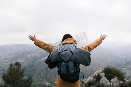 传奇大背包摄影照片_女性背包客站在山顶热爱自然