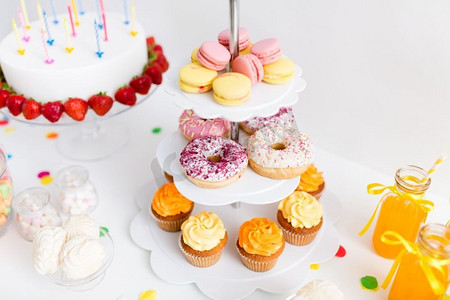 派对食品和节日概念—近摄不同糖果的立场和生日蛋糕。近摄的立场与糖果在生日聚会