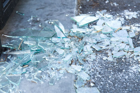 损坏概念—地板上的碎玻璃碎片。地板上的碎玻璃碎片