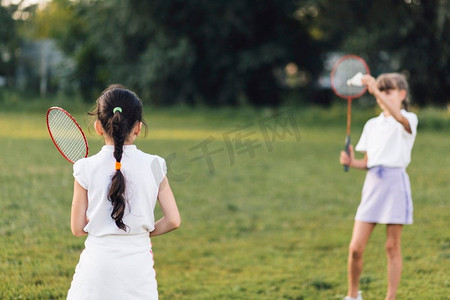 后视图女孩打羽毛球与她的朋友