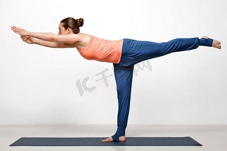 美丽的运动健身妇女练习瑜伽asana Virabhadrasana 3—战士3姿势。Woman practices yoga asana utthita