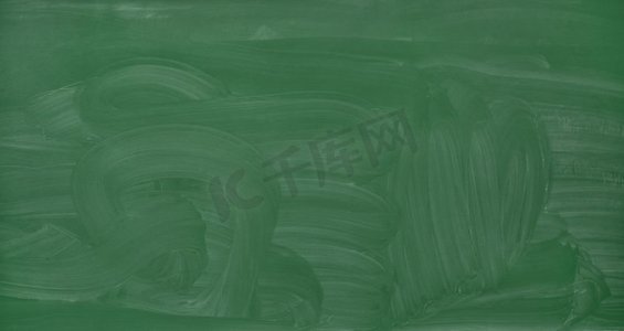 学校教学摄影照片_学校、教育和学习概念-空白的绿色黑板，带有污迹的粉笔痕迹。空白绿色黑板背景