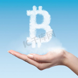 区块链蓝色摄影照片_妇女持有从云做的符号比特币在蓝色背景，虚拟货币概念比特币符号由云构成