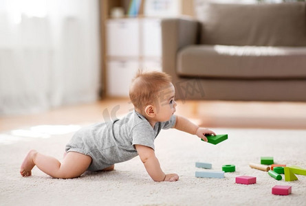儿童玩玩具摄影照片_婴儿期、儿童期和人类概念--亚洲小男婴在家玩积木玩具。亚裔男婴在家玩积木玩具