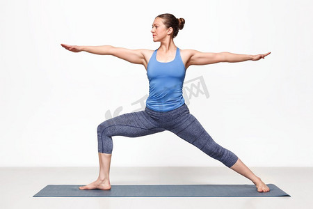 美丽的运动适合瑜伽女子练习瑜伽体位Virabhadrasana 2—战士姿势2。Woman practices yoga asana utthita Virabhadras