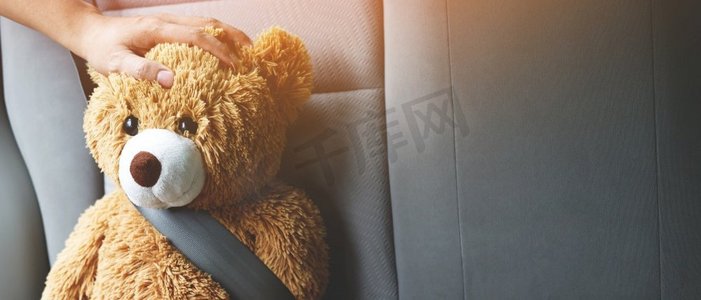 系着汽车安全带的棕色泰迪熊